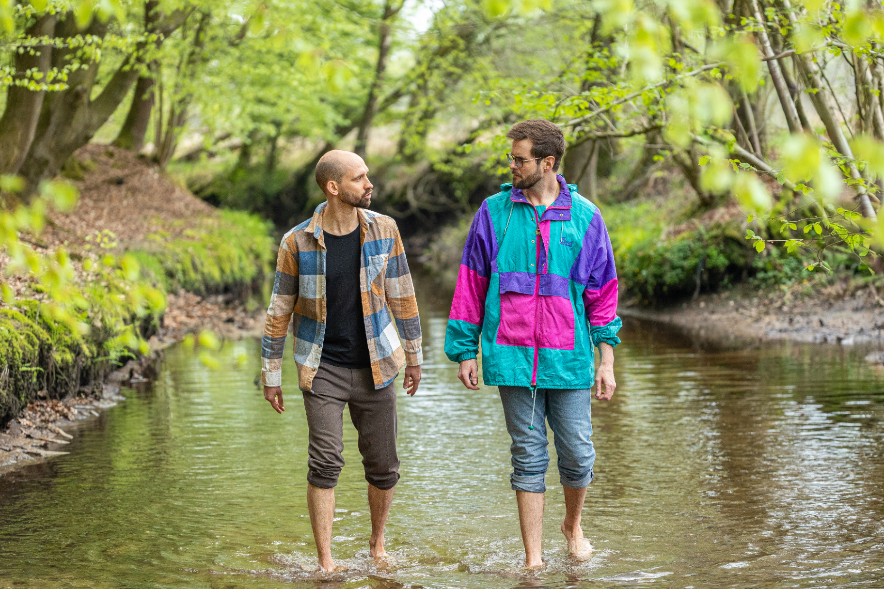 Jan walking through a forest stream with a friend